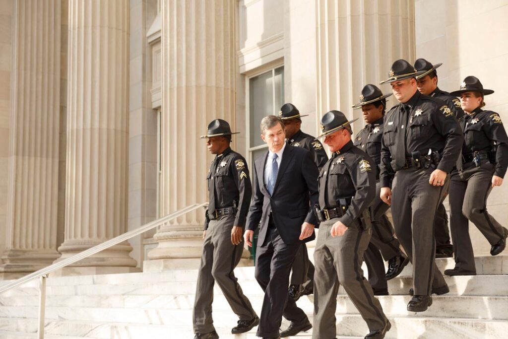 Roy Cooper and police officers going down the steps